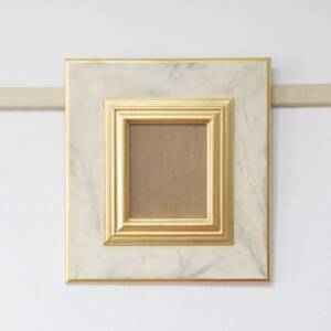 Marco dorado e imitación a mármol blanco
